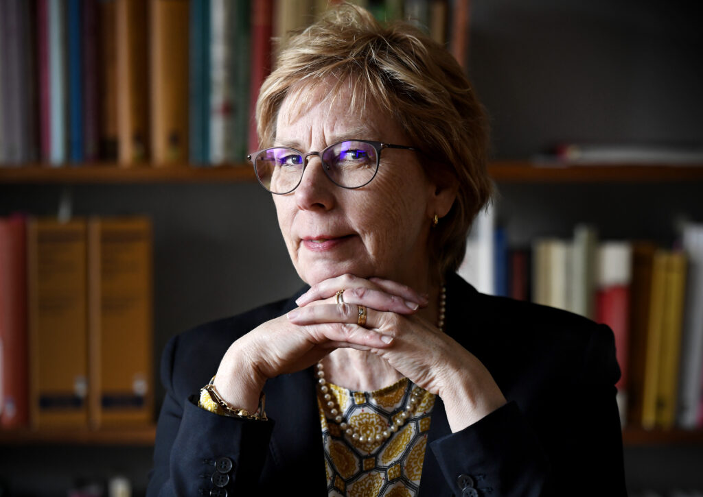 Bild på Advokat Elisabeth Nygren som sitter vid en bokhylla.